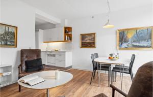 a living room with two tables and chairs and a kitchen at 1 Bedroom Stunning Apartment In Fan in Fanø