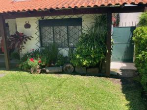 um jardim com flores e plantas em frente a uma casa em Habitación con baño privado, barbacoa y entrada independiente en carrasco em Montevidéu