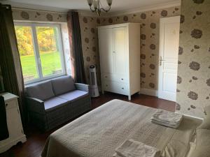 a bedroom with a bed and a chair and a window at Le Pontet in Miramont-de-Guyenne