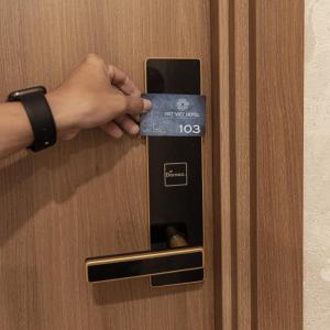 una persona que abre una puerta con una tarjeta de crédito en Nét Việt Hotel Vincom Sóc Trăng, en Soc Trang