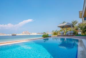 ドバイにあるVacay Lettings -Private Pool & Beach Villa at Palm Jumeirahの水辺の景色を望むスイミングプール
