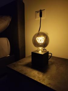 a lighted lamp on a table in a room at Sempione Apartment in Lainate