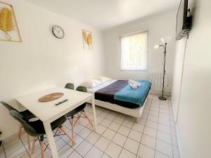 a bedroom with a bed and a table and a desk at Mai Linh - TiAM CONCIERGERIE-Disney-VILLIERS SUR MARNE CENTRE VILLE in Villiers-sur-Marne