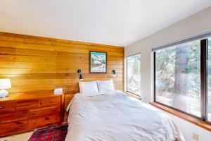 a bedroom with a bed and a wooden wall at Huntington Lake Condo #38 in Lakeshore