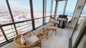 un balcone con sedie e piano cottura in un edificio di Departamento de Lujo con Terraza y Vista al Mar ad Antofagasta
