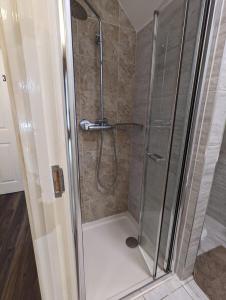 uma casa de banho com uma cabina de duche em vidro. em RAHAL BARNET em Barnet