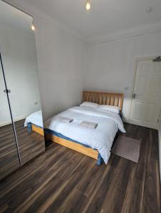 una camera con un grande letto e uno specchio di RAHAL BARNET a Barnet