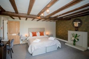 a bedroom with a large bed and a table and chairs at Tottington Manor Hotel in Henfield