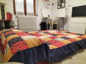 a quilt on a bed in a room at Alloggio Turistico Pratoterra in Bracciano
