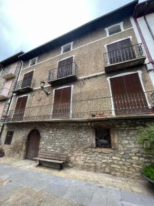 un bâtiment en pierre avec un banc devant lui dans l'établissement Casa Altemir, à Campo