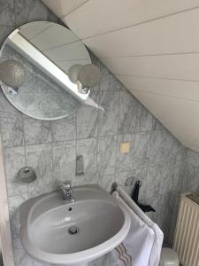 een badkamer met een wastafel en een spiegel bij Ruhiges Einzimmer-Apartment in Backnang