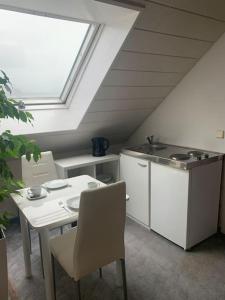 een keuken met een tafel, een wastafel en een raam bij Ruhiges Einzimmer-Apartment in Backnang
