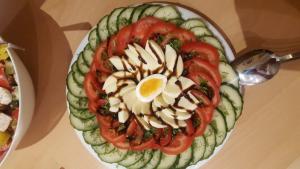 un plato de comida con tomates y un huevo. en Chalet Sonnenhang Oberhof, en Oberhof