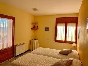 a bedroom with two beds and a window at Cal Serveró in Peramola