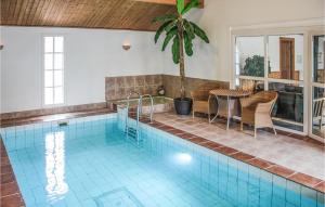 シーピンスリーにあるAwesome Home In Kpingsvik With 4 Bedrooms, Wifi And Indoor Swimming Poolの家の中のプール(テーブルと椅子付)