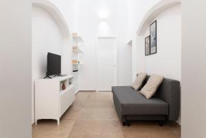 sala de estar con sofá y TV en MOH - Casa Vacanze, en Grottaglie