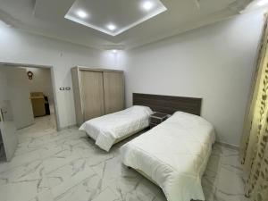 2 camas en una habitación con suelo de mármol en Oskar Appartment, en Wadi Musa