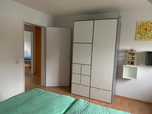 a bedroom with a white cabinet and a green bed at FeWo Saier in Althengstett