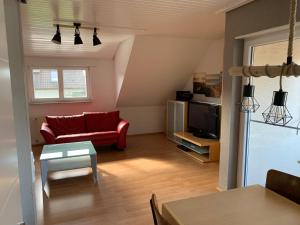 a living room with a red couch and a tv at FeWo Saier in Althengstett