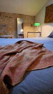 um cobertor deitado em cima de uma cama em Mon appart Teranga em Périgueux