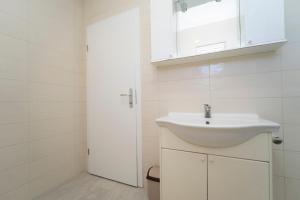 a white bathroom with a sink and a mirror at SVEMA APARTMAN in Vela Luka