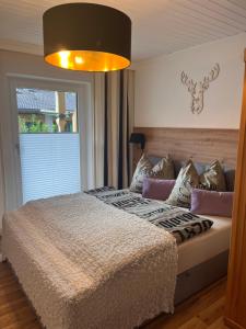 een slaapkamer met een groot bed en een groot raam bij Ferienwohnungen am Riedanger in Mayrhofen