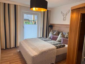 a bedroom with a bed and a large window at Ferienwohnungen am Riedanger in Mayrhofen