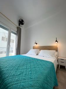 a bedroom with a large bed with a green blanket at Thèros in Ermoupoli