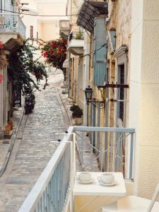 an alley with a white table on a balcony at Thèros in Ermoupoli