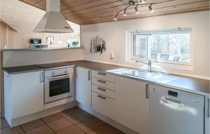 シーピンスリーにあるBeautiful Home In Kpingsvik With Kitchenの白いキャビネット、シンク、窓付きのキッチン