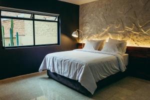 um quarto com uma cama grande e uma janela em I Believe- All Suite Manila-Poblado em Medellín