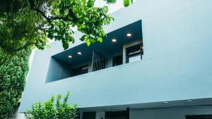 een wit huis met een raam aan de zijkant bij I Believe- All Suite Manila-Poblado in Medellín