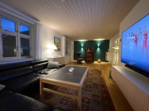 uma sala de estar com uma grande televisão de ecrã plano em Jelling em Jelling