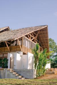 uma casa com telhado de palha e escadas em Nay Morena Villa 