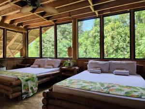two beds in a room with large windows at Nay Morena Villa 