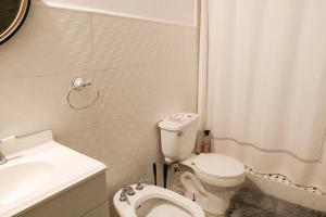 a small bathroom with a toilet and a sink at Art Inspired Apt Besides Governors Mansion in OSJ - Fort Apt 11 in San Juan