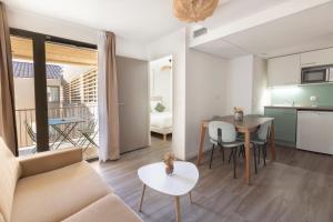 a living room with a couch and a table at The Originals Résidence Aix Schuman in Aix-en-Provence