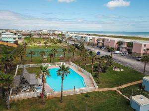 an aerial view of a resort with a pool and palm trees at IR 110: Seas the Day Port A: 2BR, 2BA, Shared Pool, Boardwalk to Beach, Golf Cart Access in Port Aransas