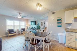 a kitchen and dining room with a table and chairs at IR 110: Seas the Day Port A: 2BR, 2BA, Shared Pool, Boardwalk to Beach, Golf Cart Access in Port Aransas