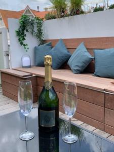 eine Flasche Wein und zwei Weingläser auf einem Tisch in der Unterkunft Beautiful Sunny Penthouse (near Place Albert) in Knokke-Heist