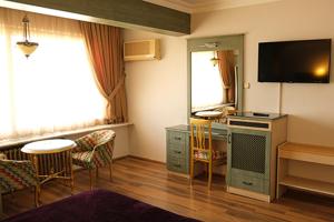 a living room with a television and a table and chairs at Karamürsel Otel (Mohti Otel - Fitness - Organizasyon) in Karamusal