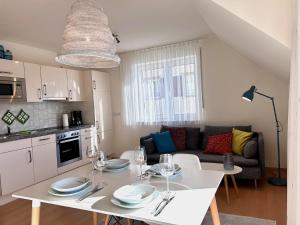 cocina y sala de estar con mesa blanca y sillas en Ferienwohnung Strandgut, en Langenargen