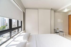 - une chambre avec un lit blanc et une grande fenêtre dans l'établissement Classic Golden Point - Boa Viagem, à Récife