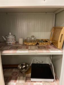 a kitchen shelf with dishes and a bowl on it at Five caravan in AlUla