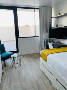 a hotel room with a bed and a chair at Modern Luxe Getaway for 2 with Stunning Cape Town Views, Fast WiFi, Queen Bed, Voice Control, Chic & Stylish Comfort in Cape Town