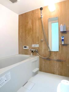a bathroom with a bath tub and a mirror at guesthouse Chikko - Vacation STAY 15111 in Osaka