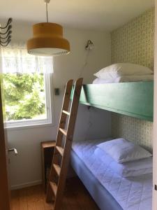 Etagenbett mit Leiter in einem Zimmer in der Unterkunft Family house 50 meters to the ocean in Buvik