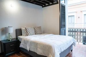 Family Getaway Apt - La Fortaleza Old San Juan - Fort Apt 4 في سان خوان: غرفة نوم بسرير ومصباح على طاولة