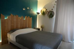 een slaapkamer met een bed en een groene muur bij L'authentique ! - Ma petite résa in Vesoul