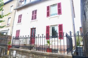 a white house with red shuttered windows and a fence at L'authentique ! - Ma petite résa in Vesoul